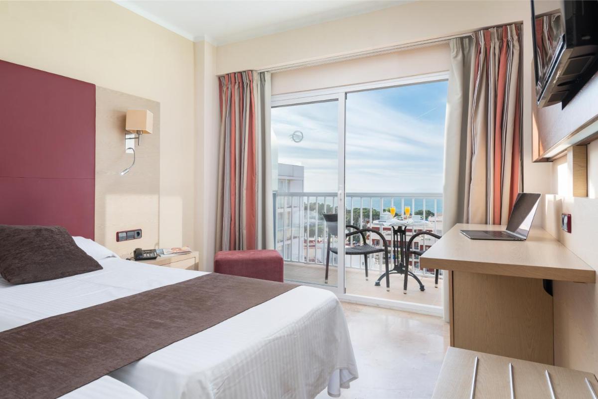 Una habitación de hotel con una cama y vista al océano. en Hotel Torre Azul & Spa - Adults Only, en El Arenal