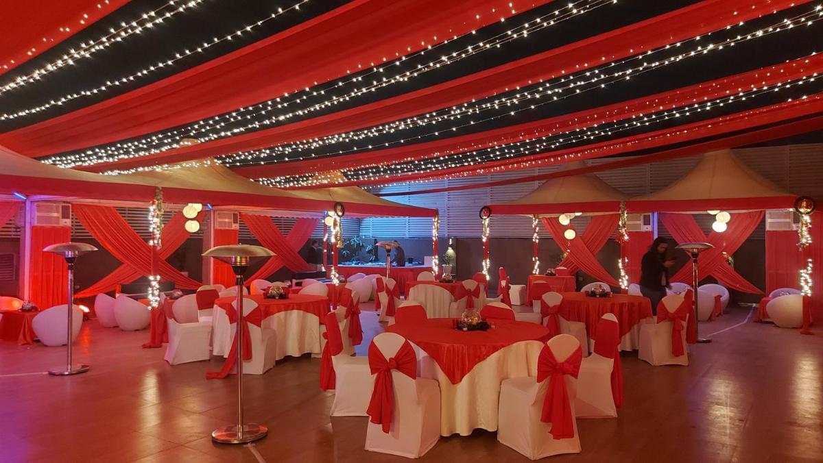 a banquet hall with red and white tables and chairs at Zone Connect by The Park Saket New Delhi in New Delhi a banquet hall with red and white tables and chairs at Zone Connect by The Park Saket New Delhi in New Delhi