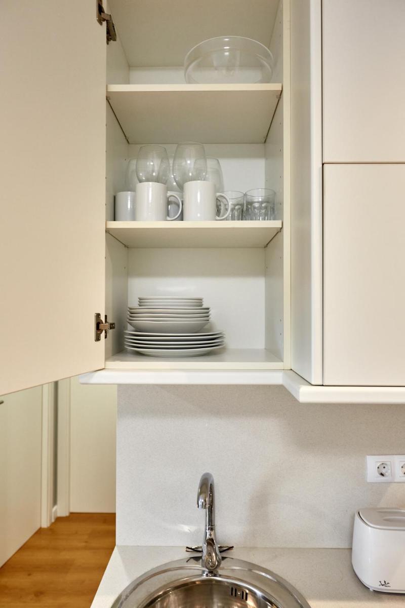un armario con platos y platos. en Apart-hotel Happy Life, en Alicante