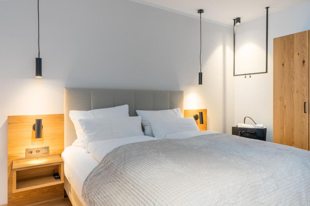 ein Schlafzimmer mit einem großen Bett mit weißer Bettwäsche in der Unterkunft zeitlang by Rösslwirt in Lam + 28 Fotos