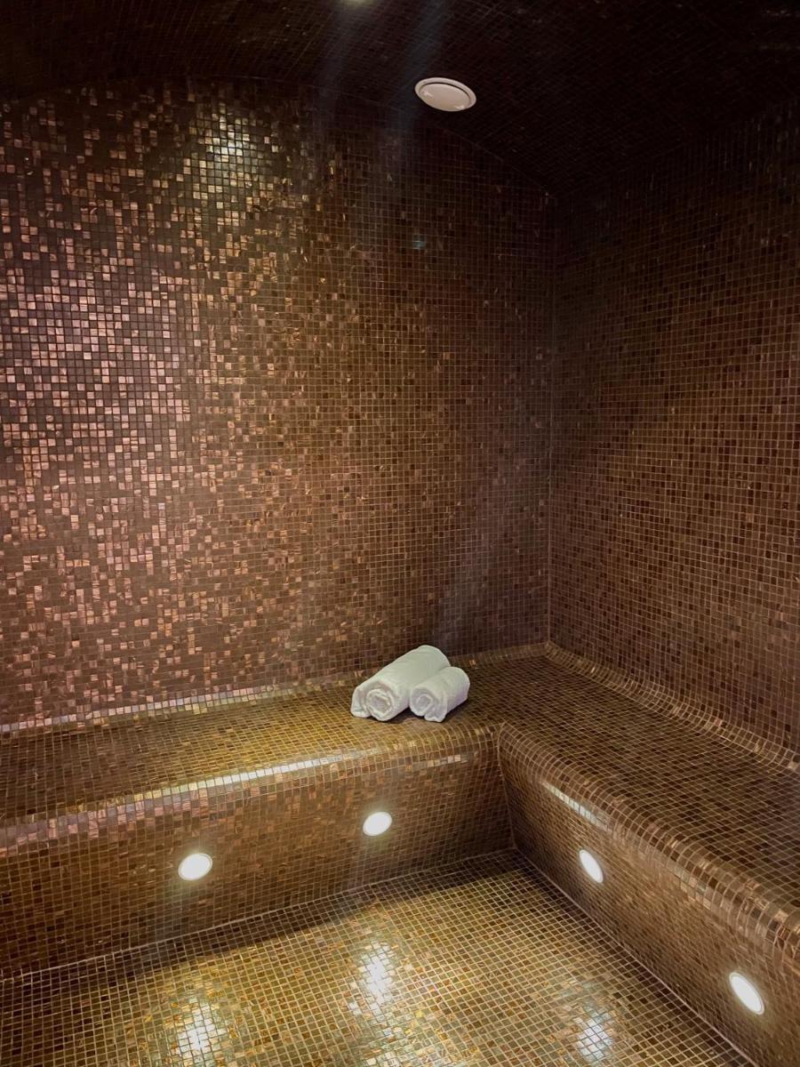 une salle de bains avec un banc sur lequel se trouvait une serviette. dans l'établissement L'INVITATION AU VOYAGE - Hôtel & Spa, à Honfleur