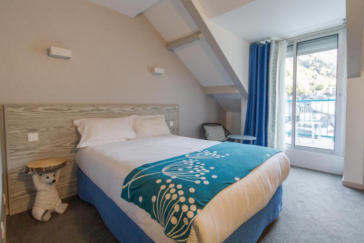 - une chambre dotée d'un lit avec un ours en peluche à côté d'une fenêtre dans l'établissement Hôtel-Résidence Le Lys, à Cauterets