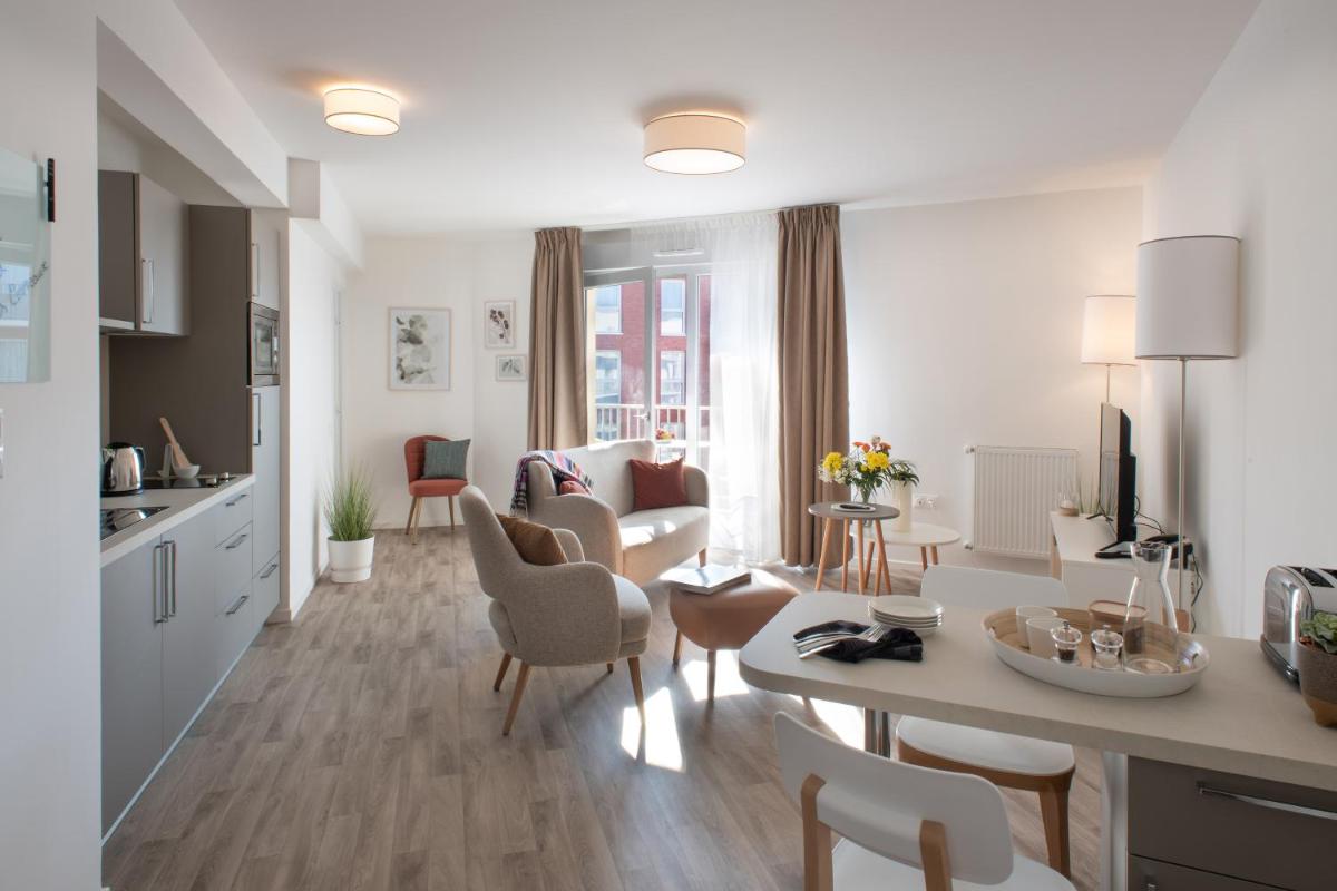 une cuisine et un salon avec une table et des chaises dans l'établissement DOMITYS L'ALLIACEE - Résidence Services Séniors, à Achères
