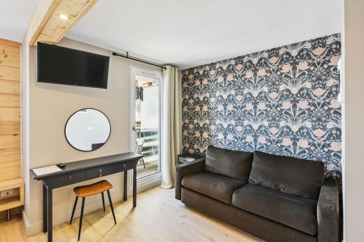 un salon avec un canapé et un miroir dans l'établissement Hotel Turan & Spa, à Les Deux Alpes