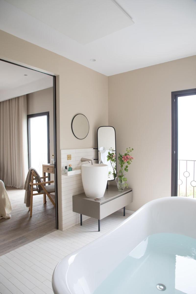une salle de bain blanche avec une baignoire et un miroir dans l'établissement Misincu, à Cagnano