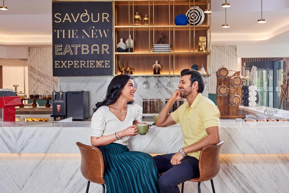 a man and a woman sitting at a table at Novotel Mumbai International Airport in Mumbai