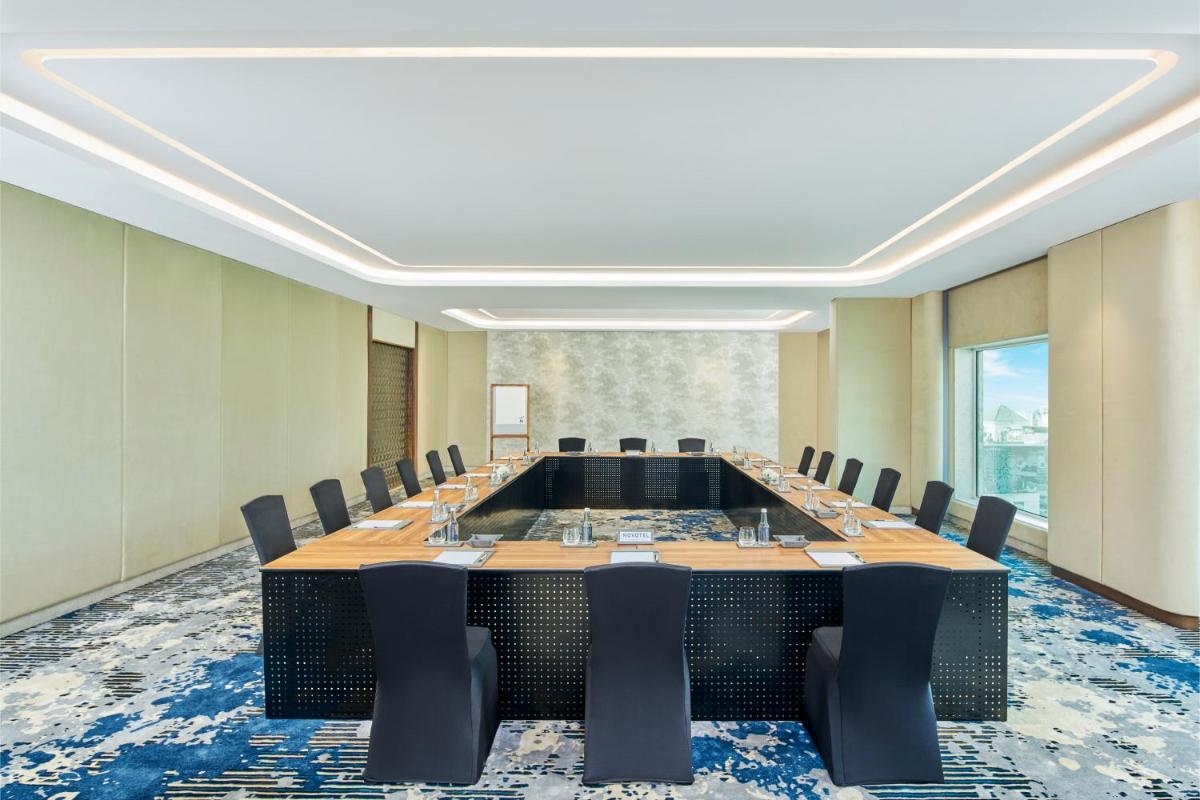 a large conference room with a large table and chairs at Novotel Mumbai International Airport in Mumbai