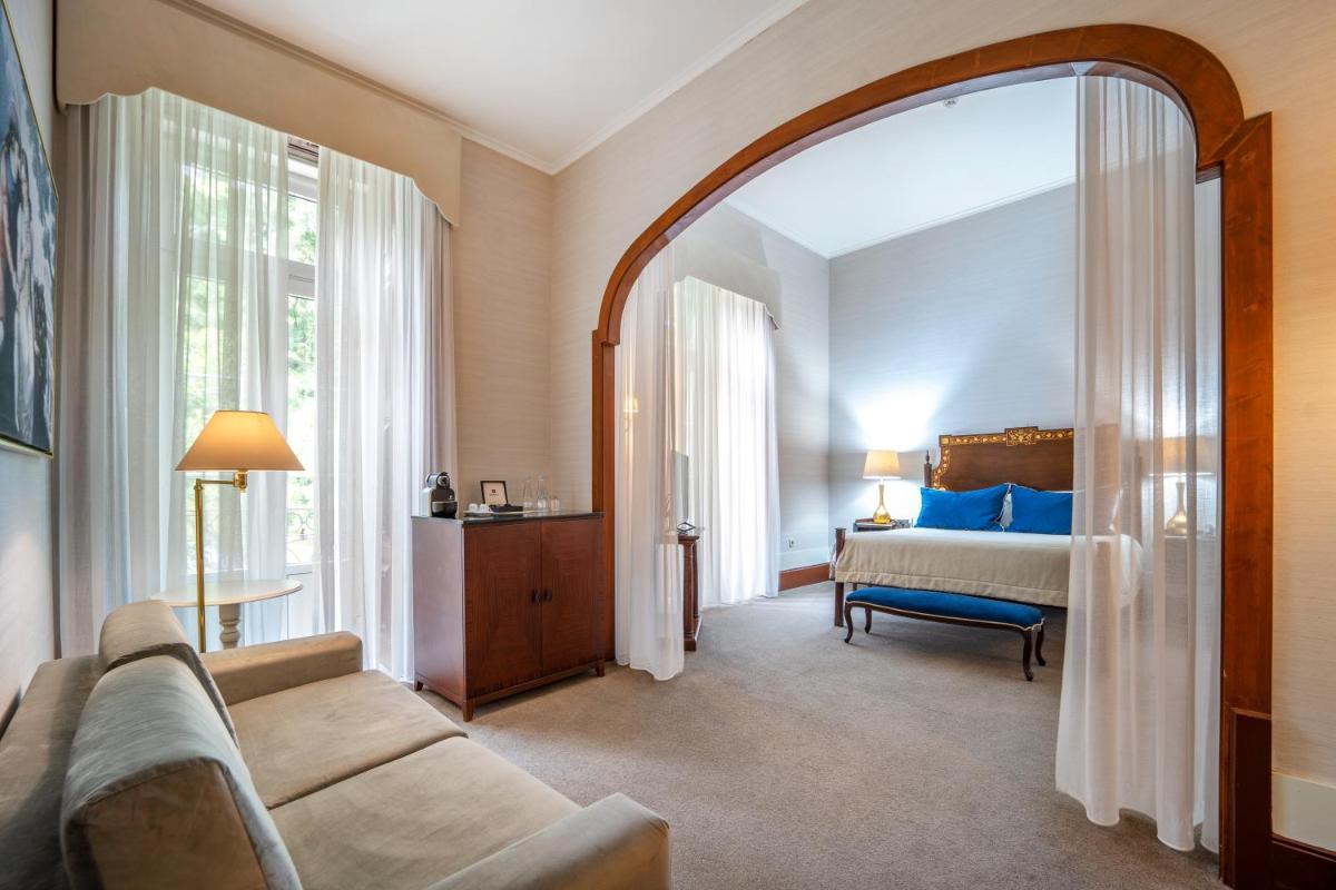 uma sala de estar com um sofá e uma cama em Hotel Quinta das Lagrimas - Small Luxury Hotels em Coimbra