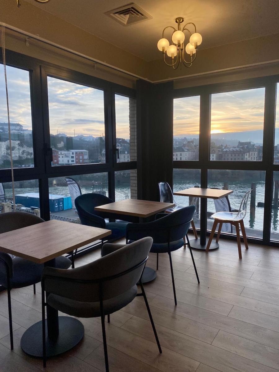 un restaurant avec des tables et des chaises et de grandes fenêtres dans l'établissement LA TOUR AUX CRABES près de la plage, à Dieppe