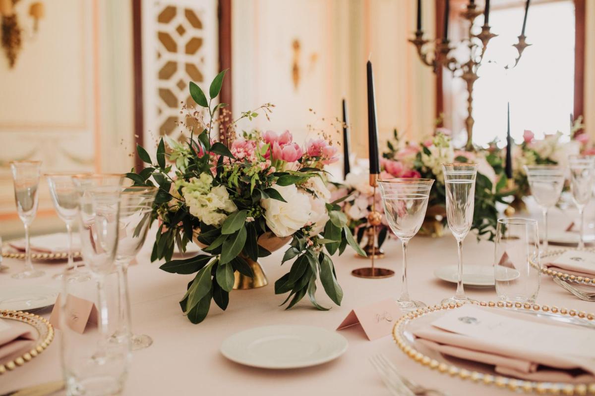 uma mesa com pratos, copos e flores sobre ela em Hotel Quinta das Lagrimas - Small Luxury Hotels em Coimbra