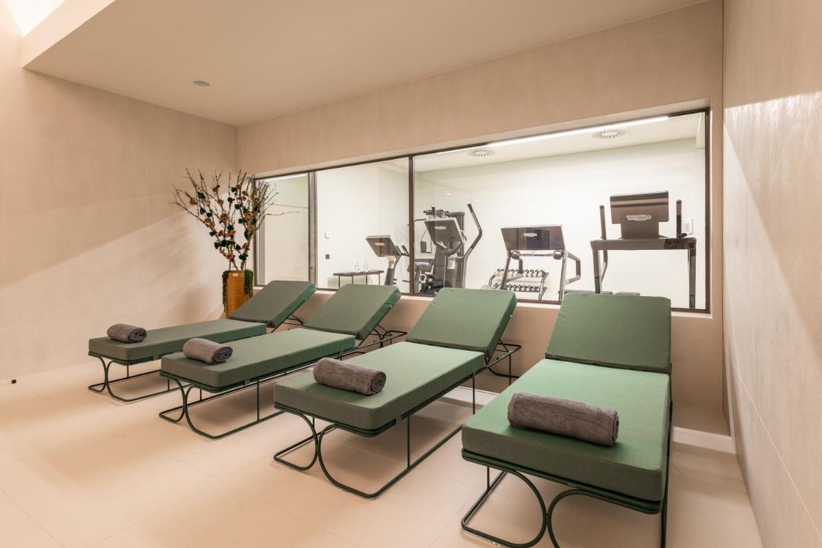 uma sala de espera com cadeiras verdes e um computador em LUSTER Hotel em Lisboa