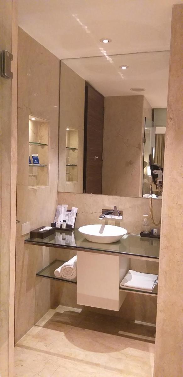 a bathroom with a sink and a mirror at Park Plaza Shahdara in New Delhi a bathroom with a sink and a mirror at Park Plaza Shahdara in New Delhi