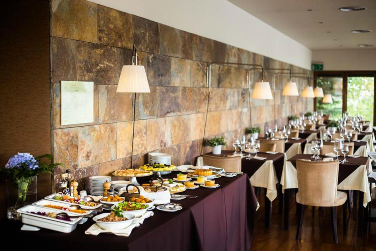 uma mesa longa com muitos pratos de comida em em Santana Hotel & SPA em Vila do Conde uma mesa longa com muitos pratos de comida em em Santana Hotel & SPA em Vila do Conde