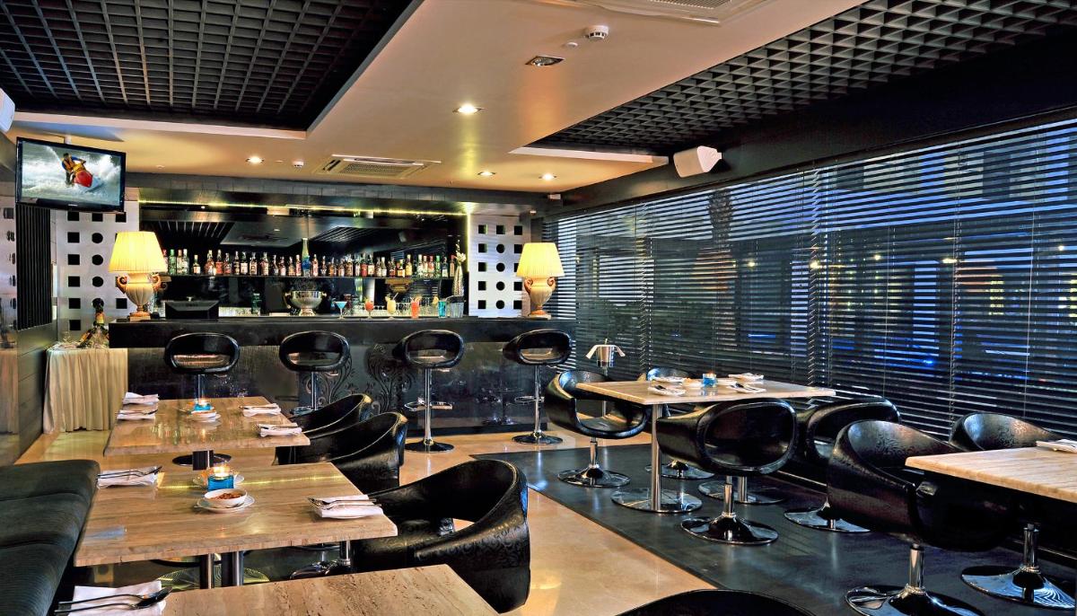 a restaurant with tables and chairs and a bar at Fortune JP Palace, Mysore - Member ITC Hotels' Group in Mysore