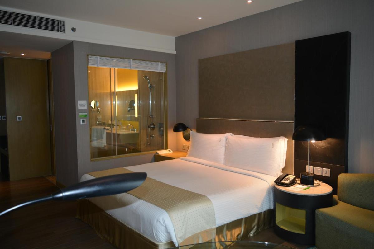 a hotel room with a bed and a chair at Holiday Inn New Delhi Aerocity by IHG in New Delhi