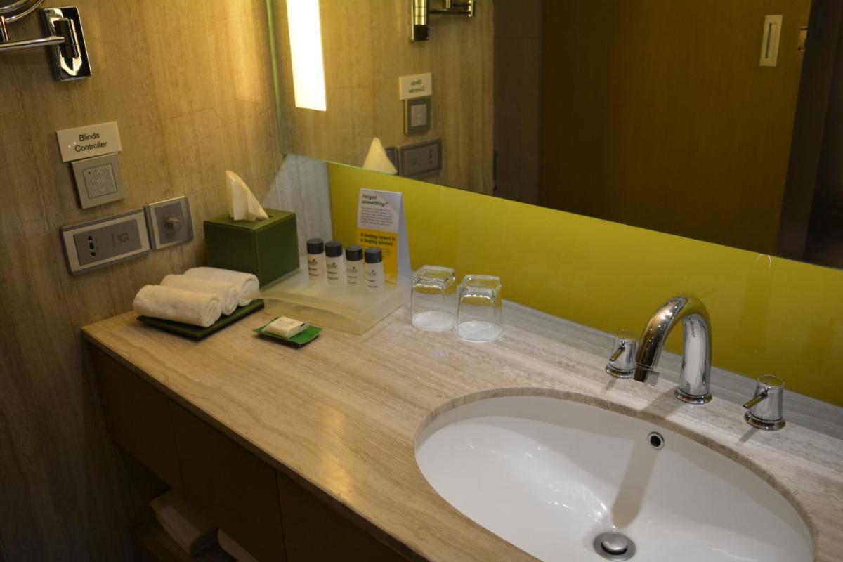 a bathroom counter with a sink and a mirror at Holiday Inn New Delhi Aerocity by IHG in New Delhi