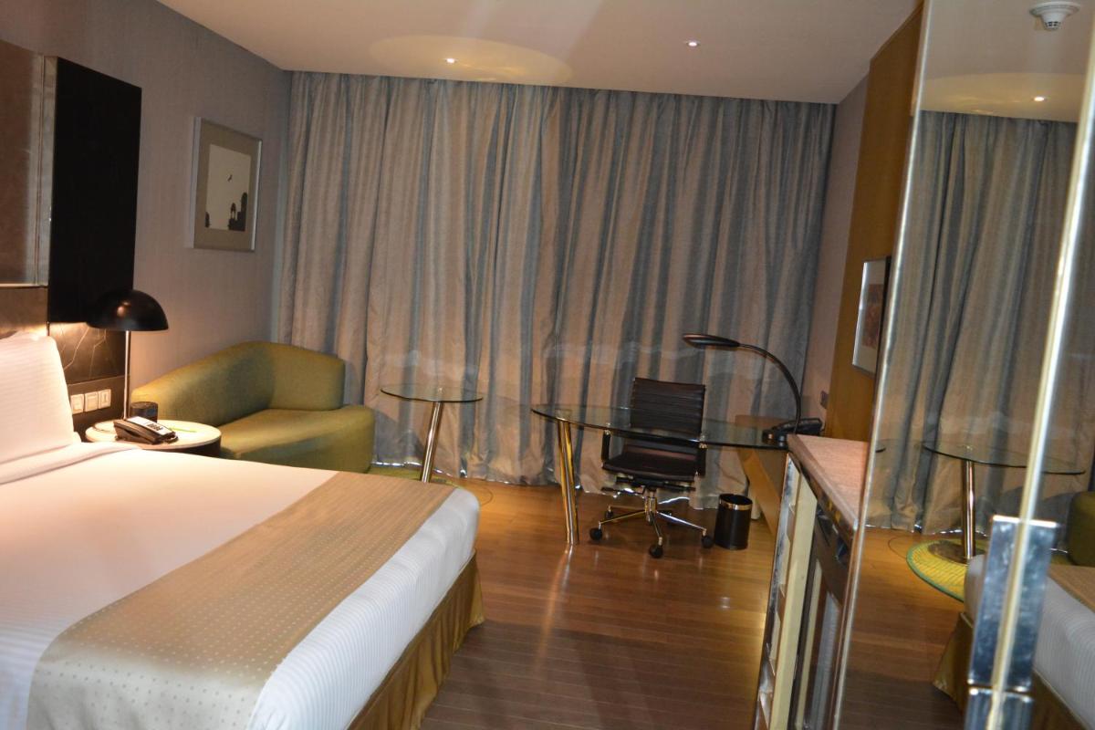 a hotel room with a bed and a chair and a desk at Holiday Inn New Delhi Aerocity by IHG in New Delhi