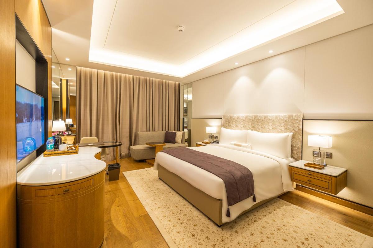 a hotel room with a bed and a bath tub at The Leela Bhartiya City Bengaluru in Bengaluru a hotel room with a bed and a bath tub at The Leela Bhartiya City Bengaluru in Bengaluru