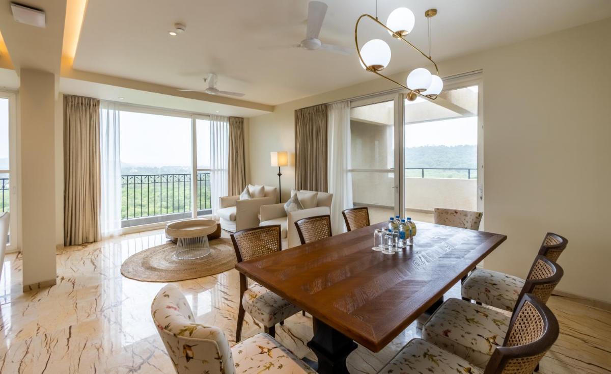 a living room with a wooden table and chairs at Holiday Inn Goa Candolim in Candolim a living room with a wooden table and chairs at Holiday Inn Goa Candolim in Candolim