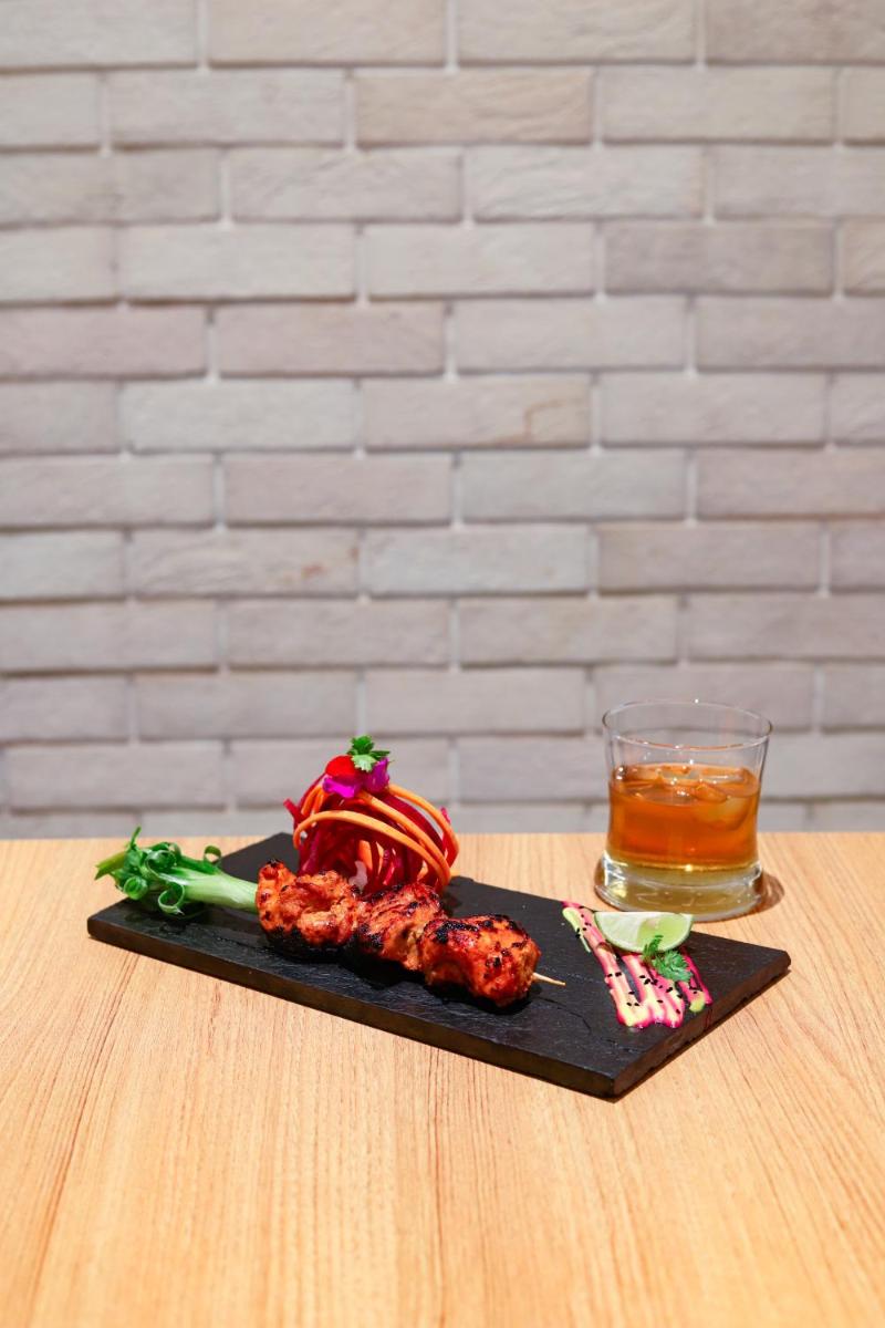 a plate of food on a table with a drink at Lemon Tree Premier, Mumbai International Airport in Mumbai
