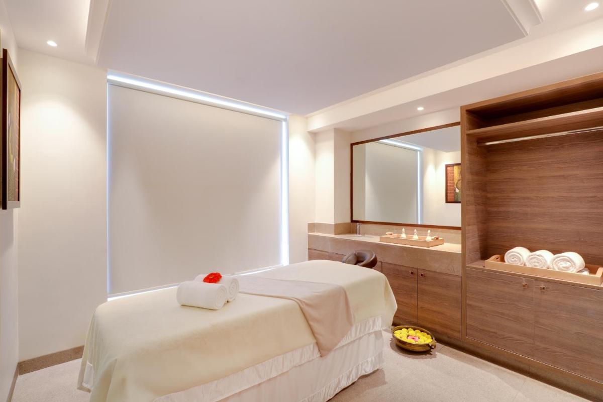 a bedroom with a bed and a large mirror at Lemon Tree Premier, Mumbai International Airport in Mumbai
