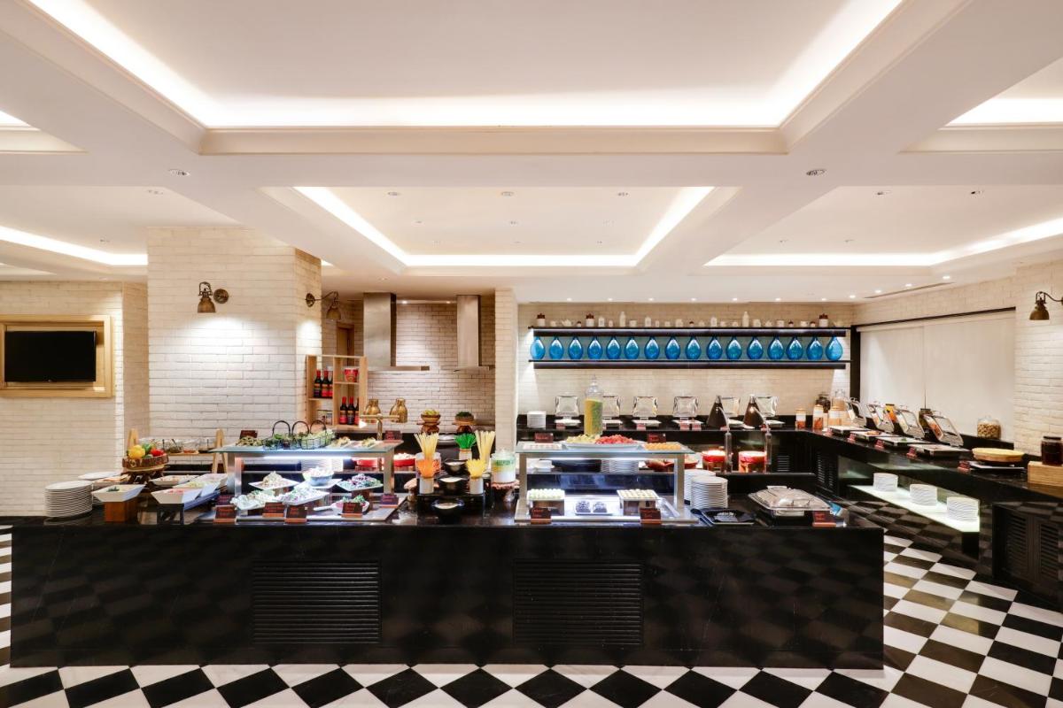 a restaurant with a buffet line with people in it at Lemon Tree Premier, Mumbai International Airport in Mumbai