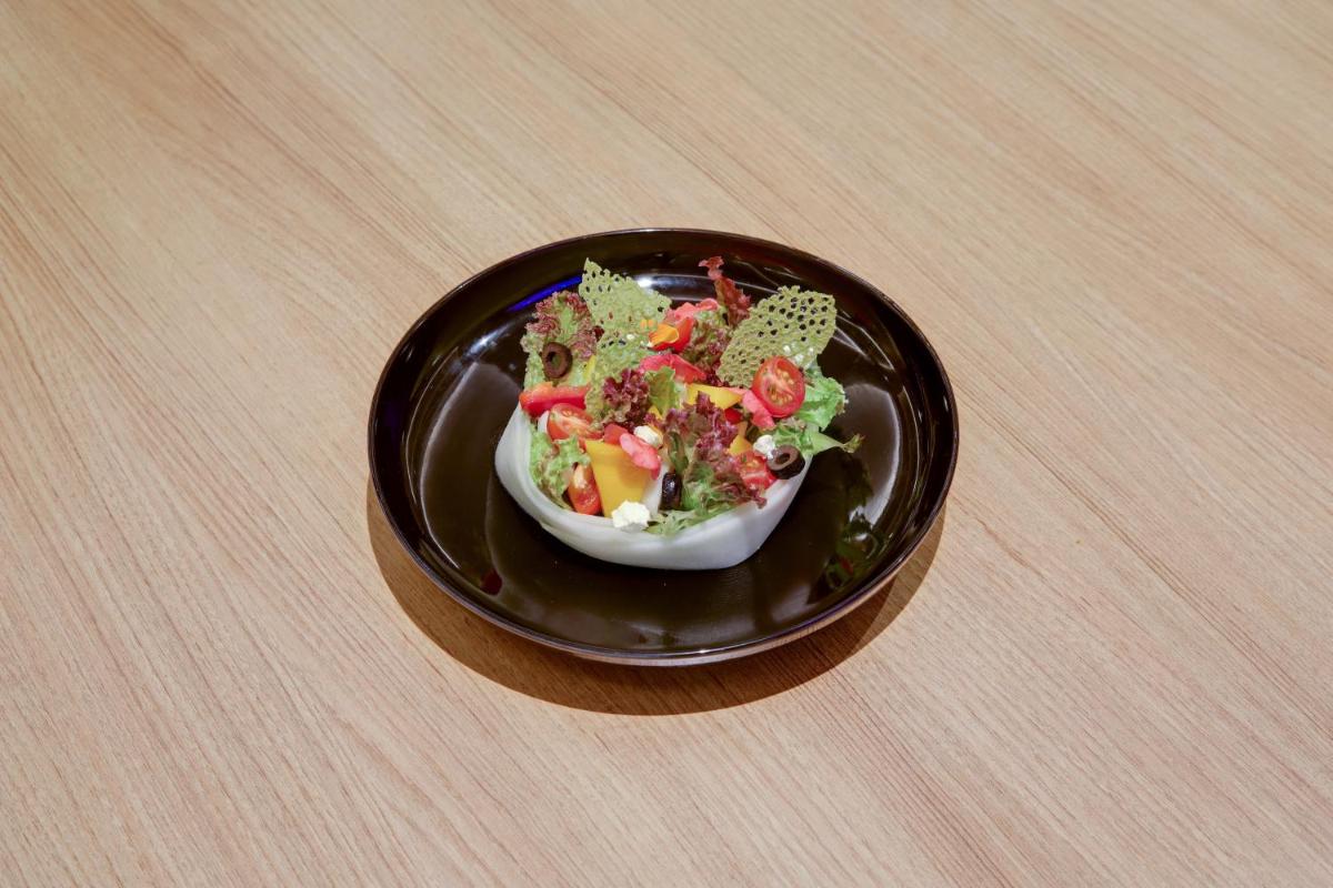 a bowl of salad on a plate on a table at Lemon Tree Premier, Mumbai International Airport in Mumbai