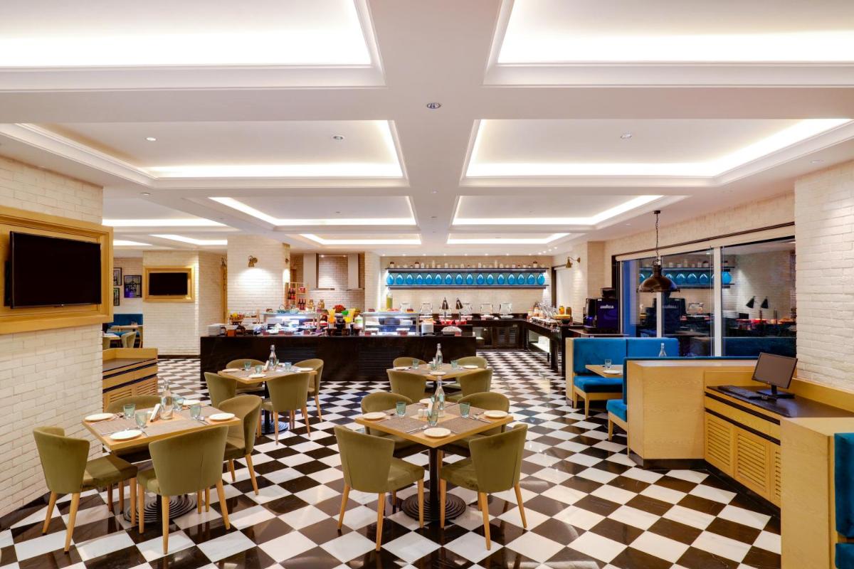 a restaurant with tables and chairs on a checkered floor at Lemon Tree Premier, Mumbai International Airport in Mumbai a restaurant with tables and chairs on a checkered floor at Lemon Tree Premier, Mumbai International Airport in Mumbai