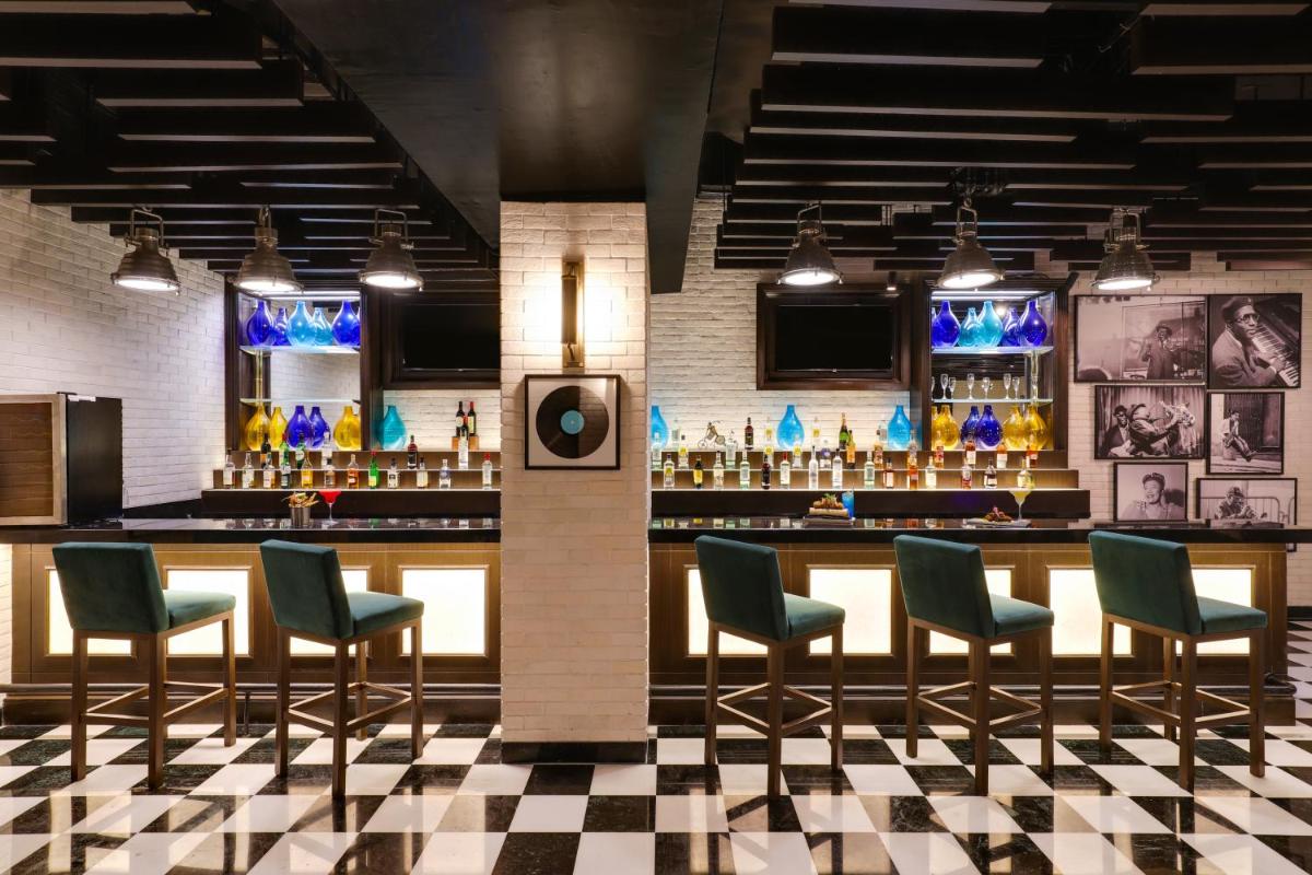 a bar with chairs and a counter in a room at Lemon Tree Premier, Mumbai International Airport in Mumbai