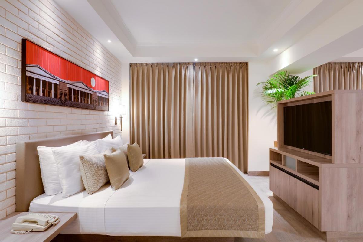 a bedroom with a white bed and a flat screen tv at Lemon Tree Premier, Mumbai International Airport in Mumbai