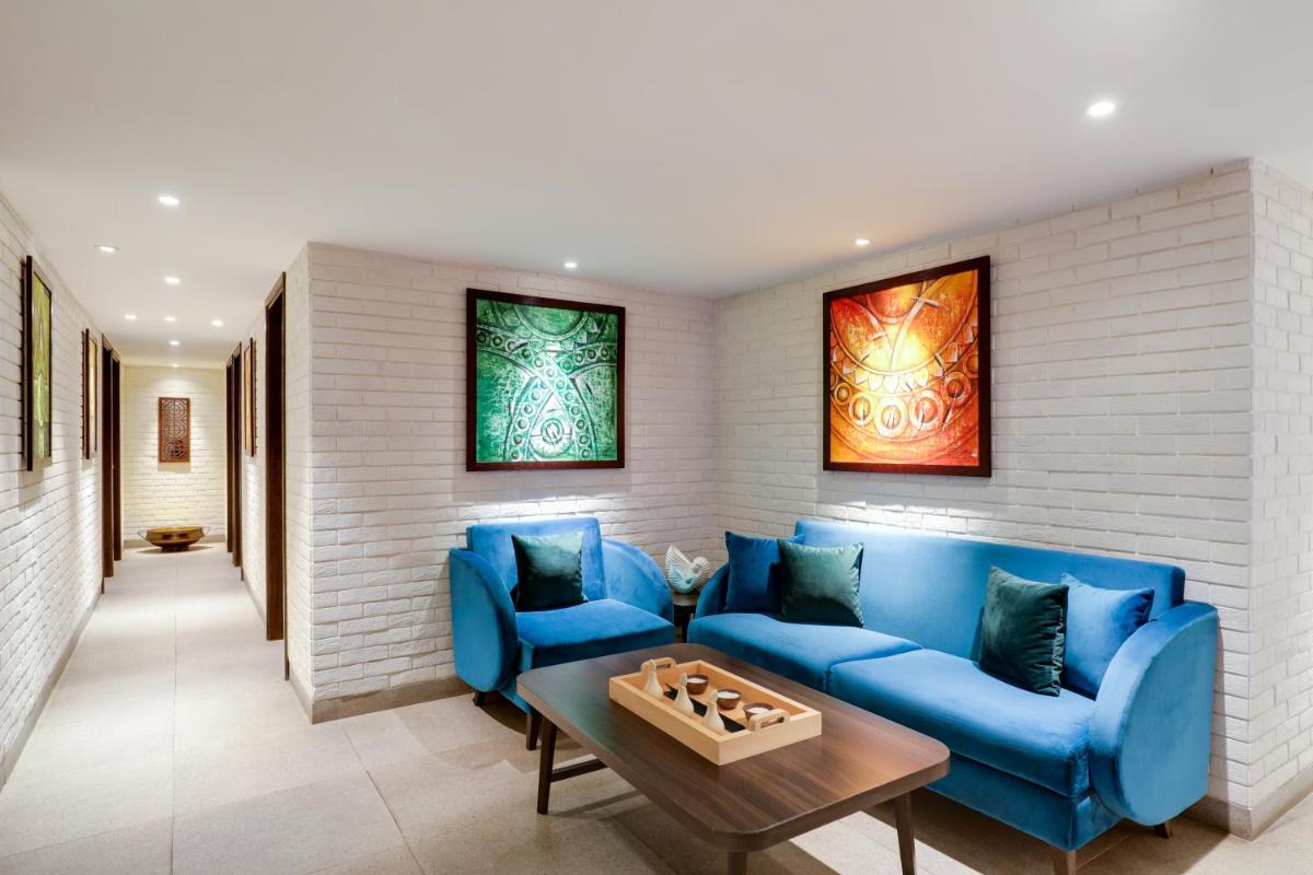 a living room with blue couches and a table at Lemon Tree Premier, Mumbai International Airport in Mumbai