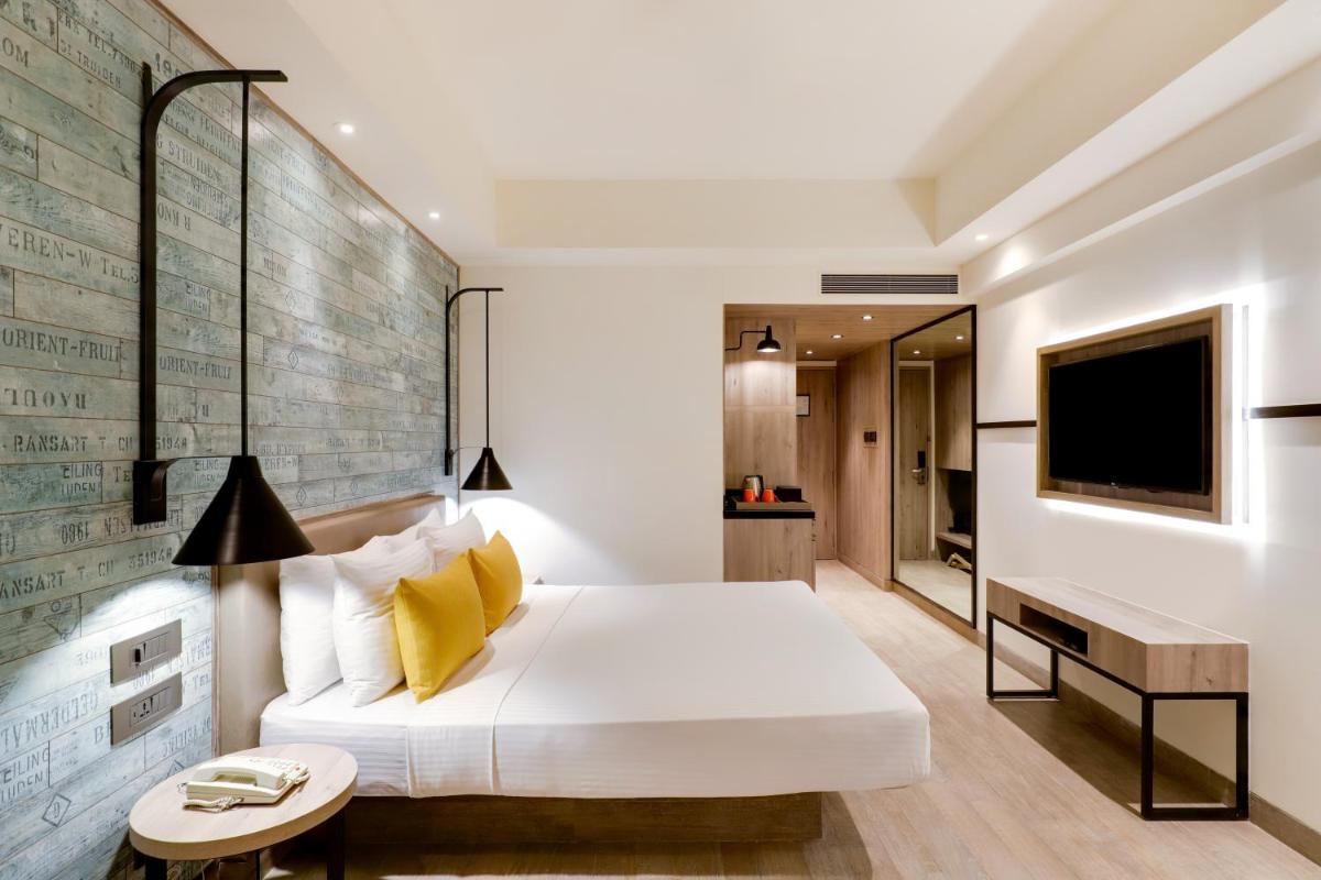 a bedroom with a large bed and a television at Lemon Tree Premier, Mumbai International Airport in Mumbai +40 photos