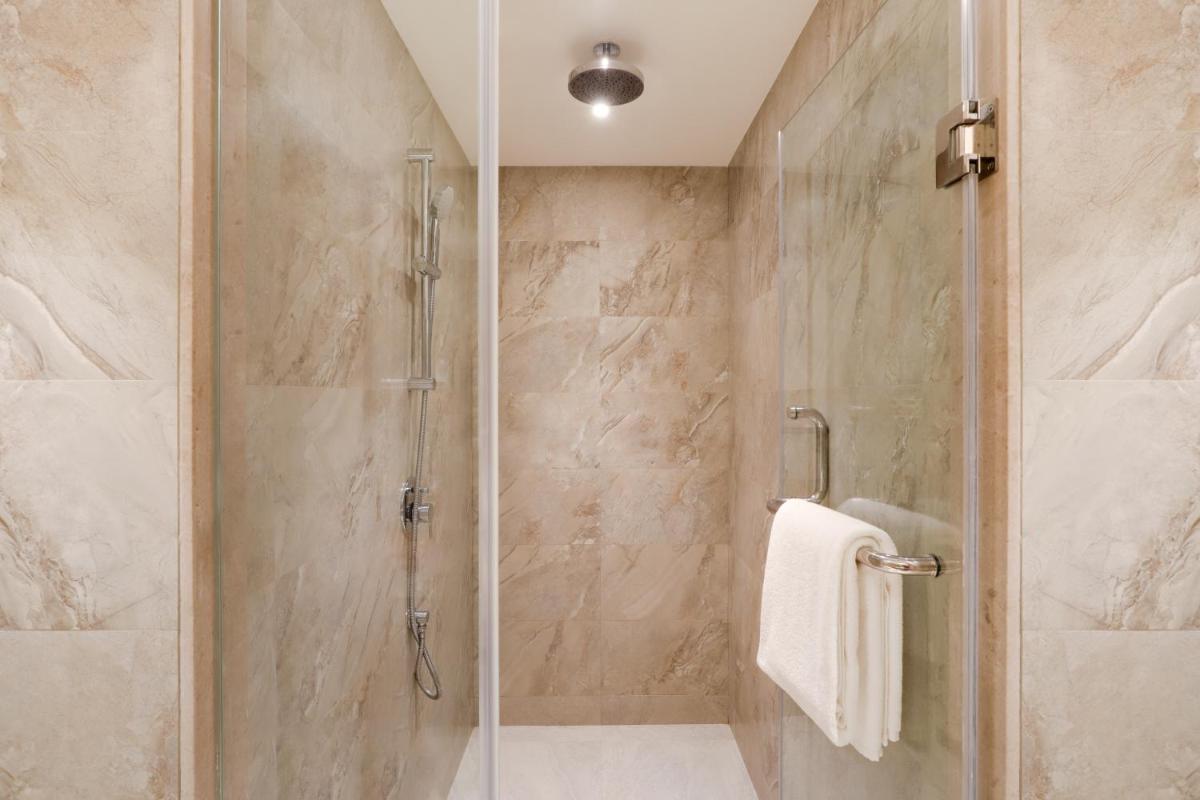 a bathroom with a shower with a glass door at Lemon Tree Premier, Mumbai International Airport in Mumbai