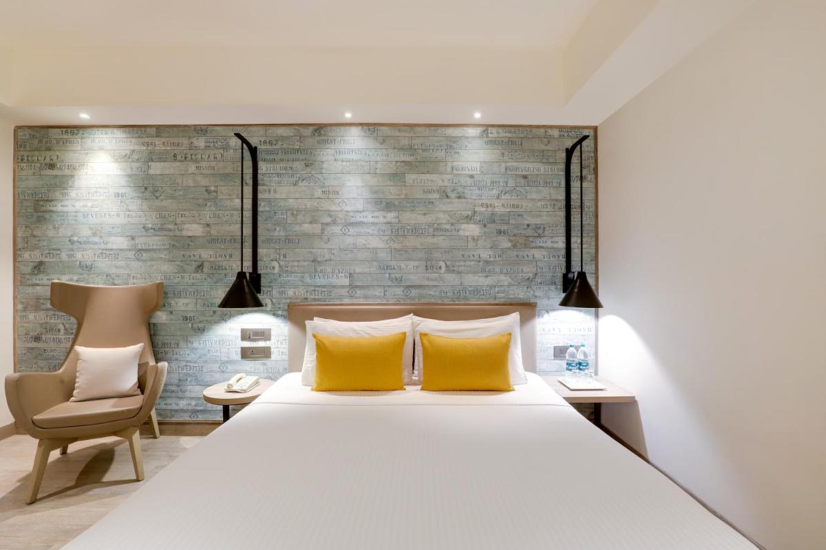 a bedroom with a large bed with yellow pillows at Lemon Tree Premier, Mumbai International Airport in Mumbai