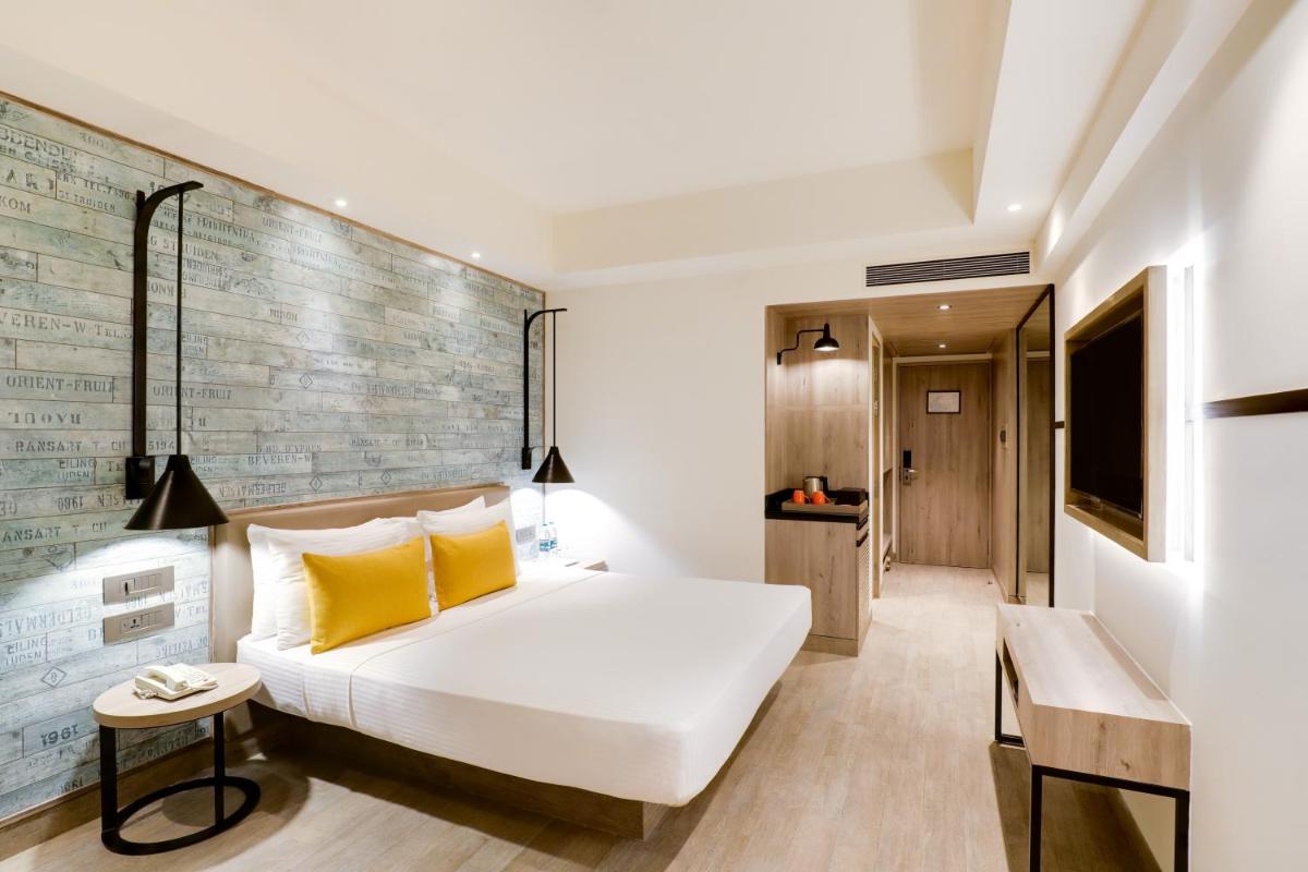 a hotel room with a bed and a television at Lemon Tree Premier, Mumbai International Airport in Mumbai