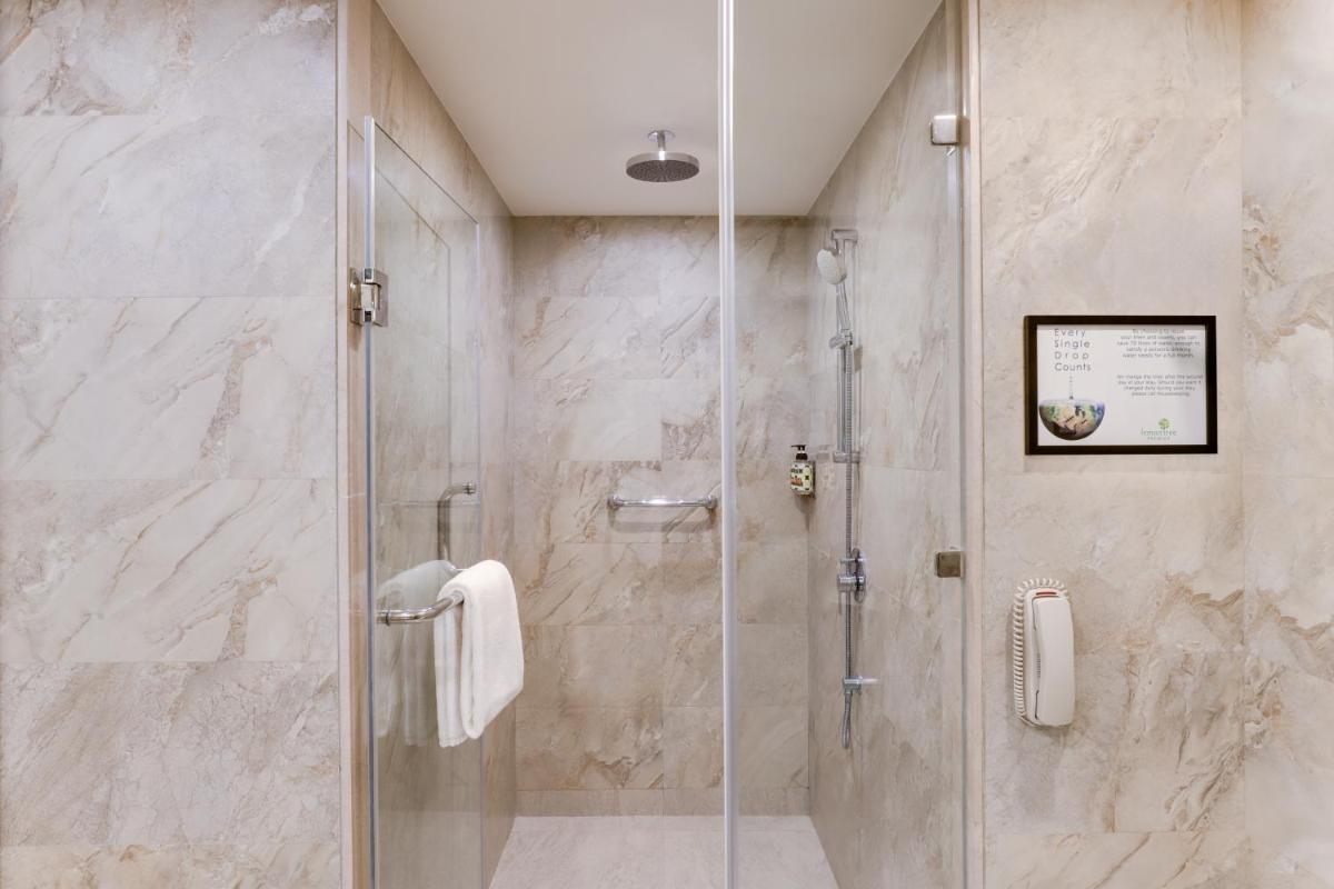 a shower with a glass door in a bathroom at Lemon Tree Premier, Mumbai International Airport in Mumbai