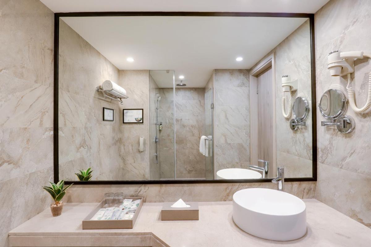 a bathroom with a sink and a shower at Lemon Tree Premier, Mumbai International Airport in Mumbai a bathroom with a sink and a shower at Lemon Tree Premier, Mumbai International Airport in Mumbai