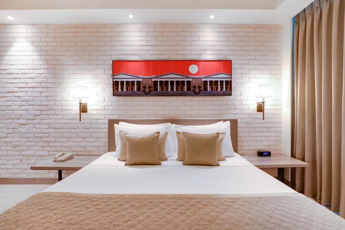 a bedroom with a large white bed with two tables at Lemon Tree Premier, Mumbai International Airport in Mumbai