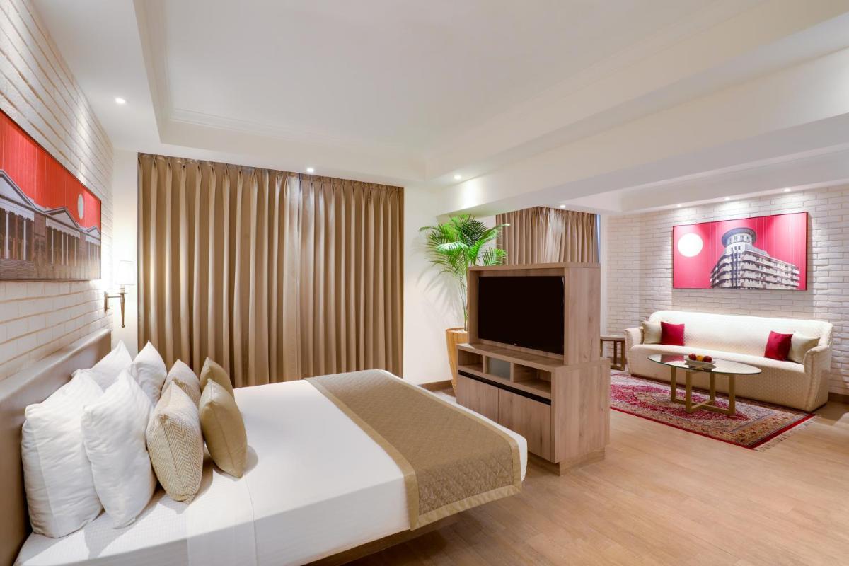 a hotel room with a bed and a television at Lemon Tree Premier, Mumbai International Airport in Mumbai a hotel room with a bed and a television at Lemon Tree Premier, Mumbai International Airport in Mumbai
