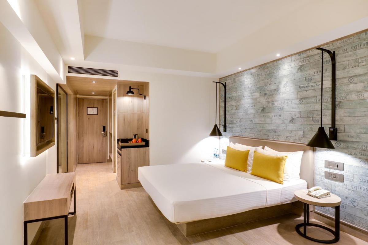 a bedroom with a white bed with yellow pillows at Lemon Tree Premier, Mumbai International Airport in Mumbai