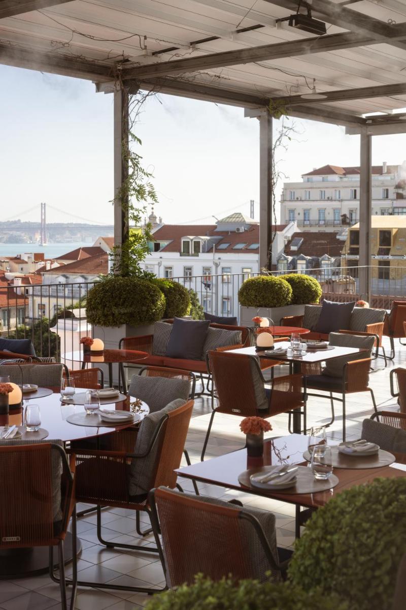 um restaurante com mesas e cadeiras no terraço em Bairro Alto Hotel em Lisboa