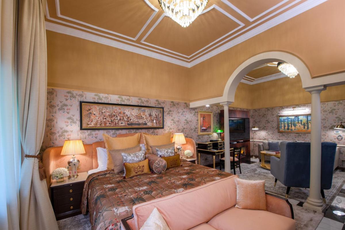 a bedroom with a large bed and a couch at The Claridges New Delhi in New Delhi a bedroom with a large bed and a couch at The Claridges New Delhi in New Delhi