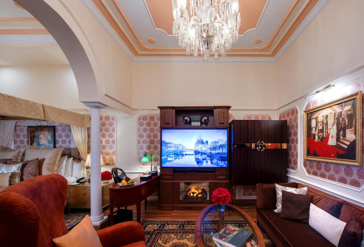 a living room with a fireplace and a television at The Claridges New Delhi in New Delhi a living room with a fireplace and a television at The Claridges New Delhi in New Delhi