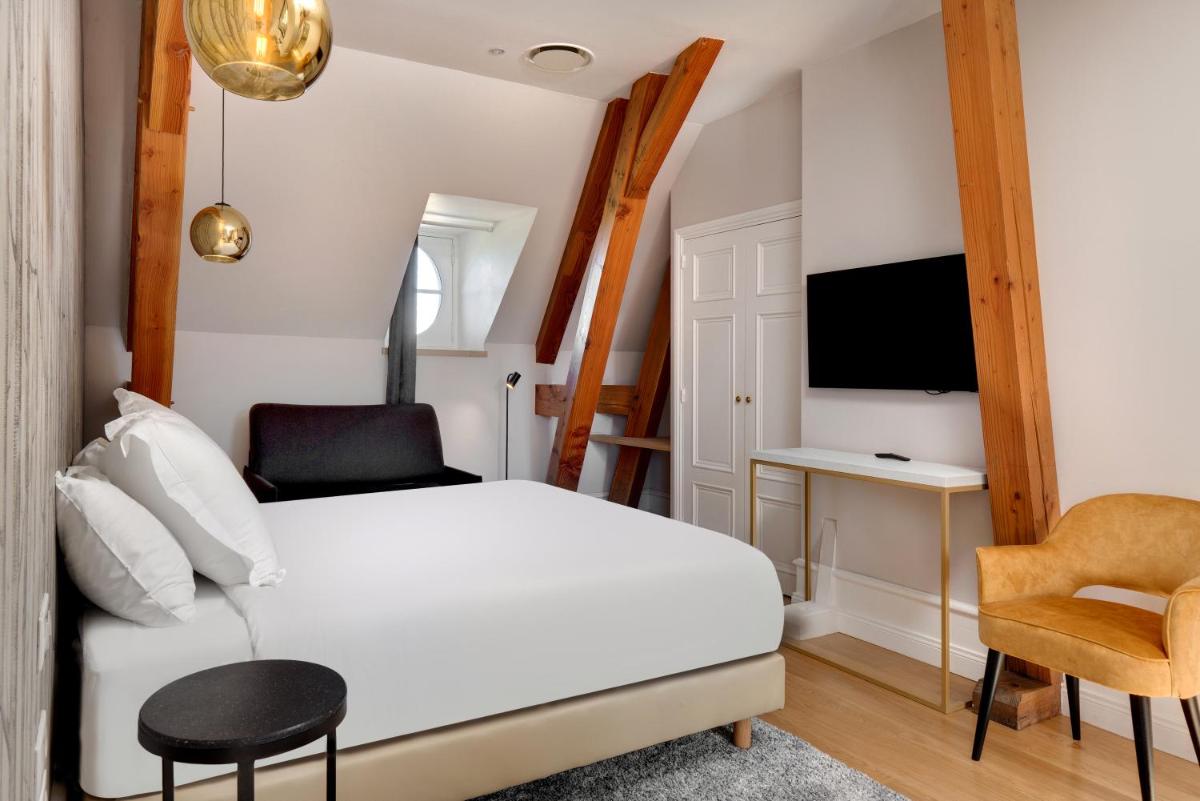 - une chambre avec un lit blanc, un bureau et une chaise dans l'établissement Alexandra Palace - La Maison Younan, à Mazières-en-Gâtine