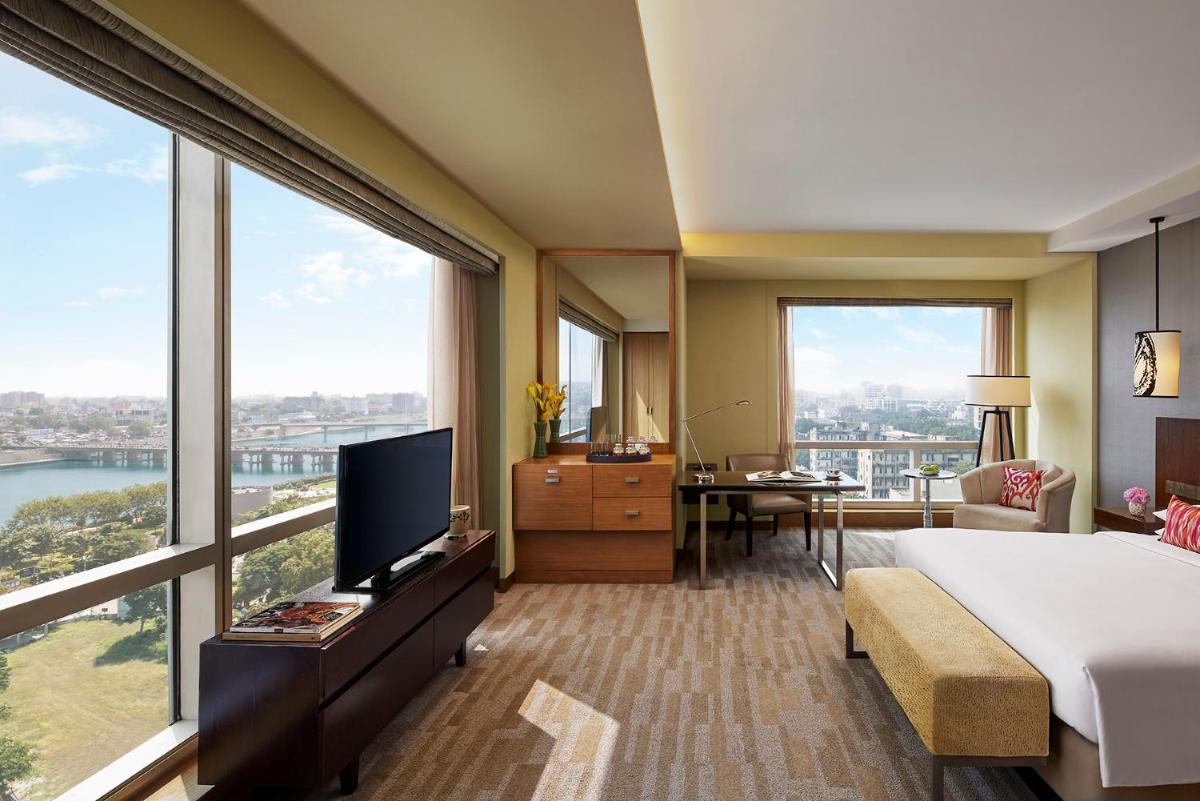 a hotel room with a bed and a large window at Hyatt Regency Ahmedabad in Ahmedabad
