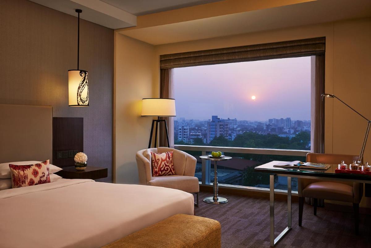 a hotel room with a bed and a large window at Hyatt Regency Ahmedabad in Ahmedabad