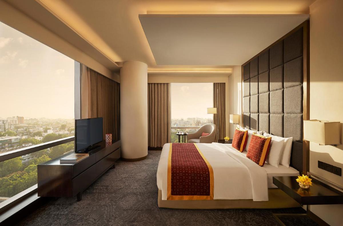 a hotel room with a bed and a television at Hyatt Regency Ahmedabad in Ahmedabad