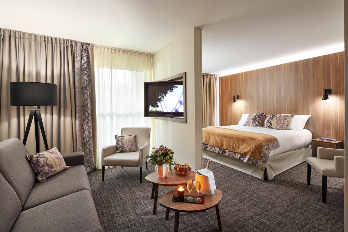 une chambre d'hôtel avec un lit et un canapé dans l'établissement Le Forges Hotel, à Forges-les-Eaux