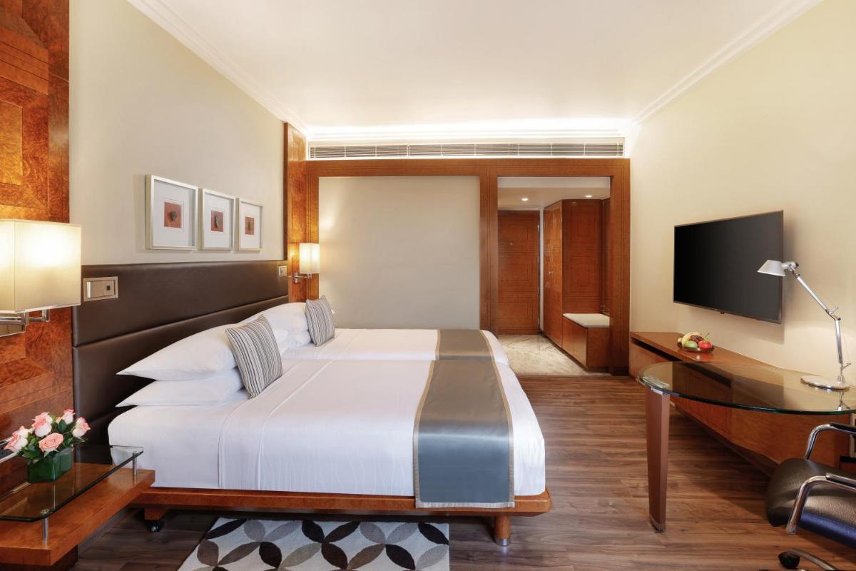 a hotel room with a bed and a television at Hyatt Regency Delhi in New Delhi a hotel room with a bed and a television at Hyatt Regency Delhi in New Delhi