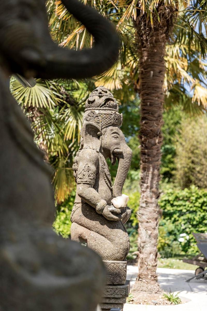 une statue d'éléphant se tenant à côté d'un arbre dans l'établissement Manoir des Indes, The Originals Relais, à Quimper